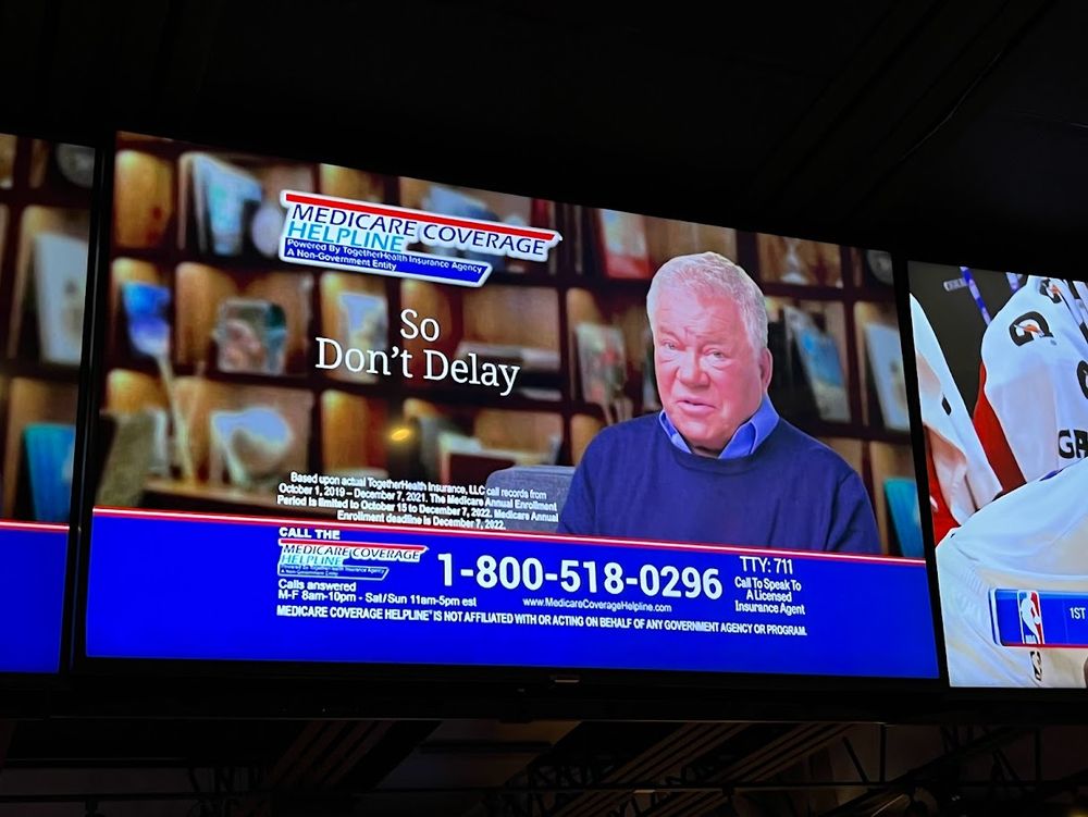 A Sunday television program showing a "MEDICARE COVERAGE HELPLINE" advertisement featuring WIlliam Shatner as a paid spokesman