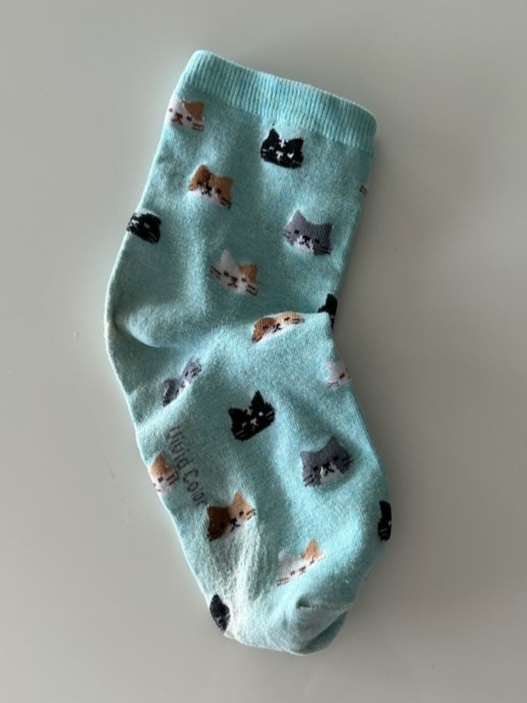 Turquoise sock with cartoon cat faces (calico, black, gray)