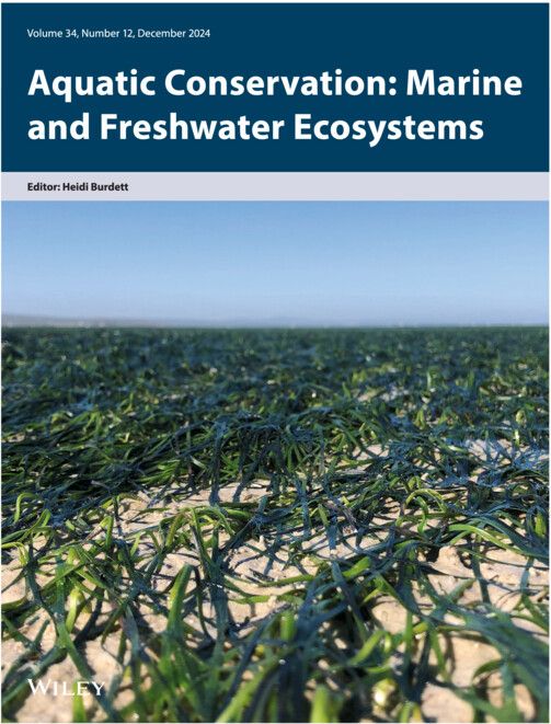 Journal front cover with title header for the journal Aquatic Conservation, with an image undernearth of an intertidal seagrass meadow at low tide, with the seagrass blades lying flat on the sand. Photo credit: Sophie von der Heyden