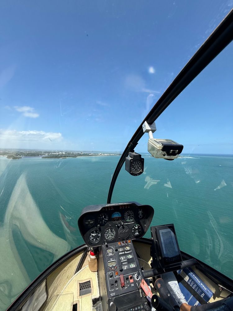 View of the ocean from the left seat of a Robinson R44 helicopter in Puerto Rico. 