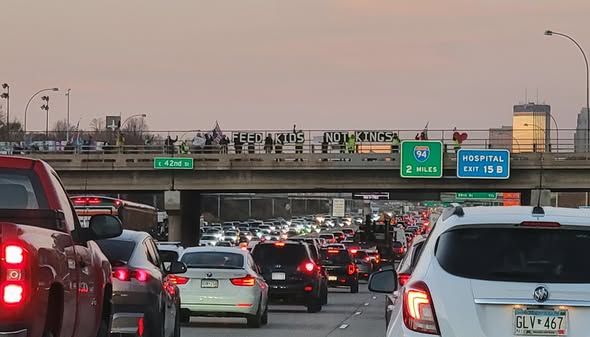 Democracy Bridge! dmbr.org
Minneapolis MN
banners FEED KIDS NOT KINGS - ALL EPSTEIN FILES NOW
-heavy traffic & Hwy signs 42nd St - 94 - 2 MILES - HOSPITAL EXIT 15 B