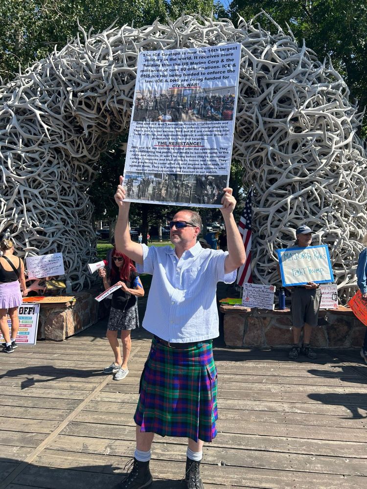 Resisters in front of Elk Antler Arch Jackson Town Square, -person in kilt