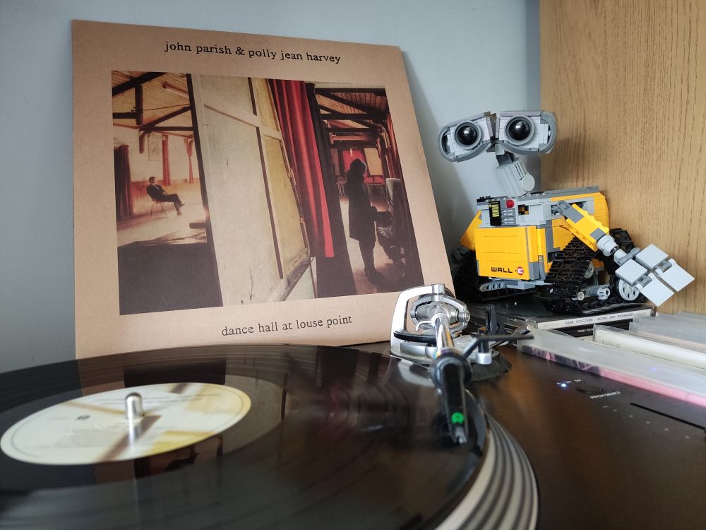 Dance Hall at Louse Point by John Parish and Polly Jean Harvey. A black vinyl LP on a Stanton turntable. Lego Wall-E looks on from the right of the picture.