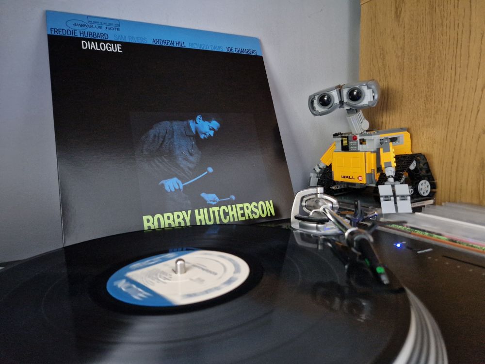 Dialogue by Bobby Hutcherson (featuring Freddie Hubbard, Sam Rivers, Andrew Hill, Richard Davis and Joe Chambers). A black vinyl LP on a Stanton turntable with the record sleeve placed behind it. A Lego Wall-E looks on from the right hand side of the picture.