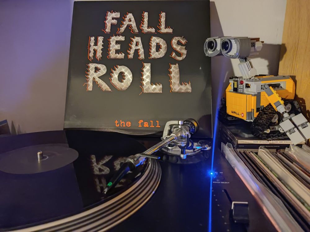 Fall Heads Roll, a black vinyl double LP on a Stanton turntable. Lego Wall-E looks on from the right of the picture.