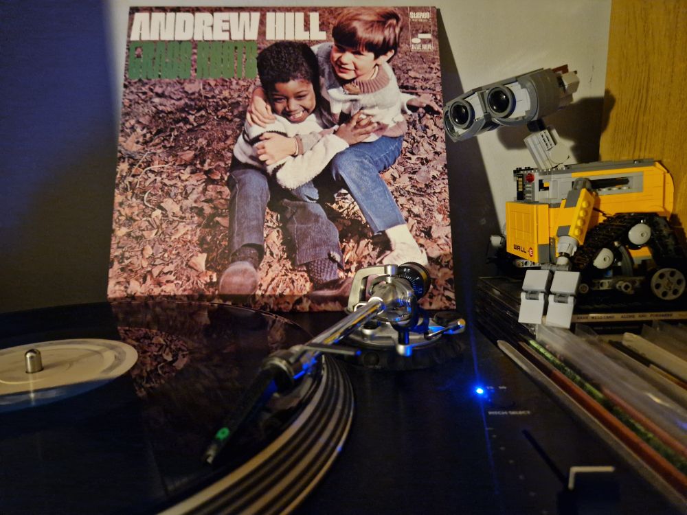 Grass Roots by Andrew Hill, featuring Lee Morgan, Booker Ervin, Ron Carter and Freddie White. A black vinyl LP on a Stanton turntable with the record sleeve placed behind it. A Lego Wall-E looks on from the right hand side of the picture.