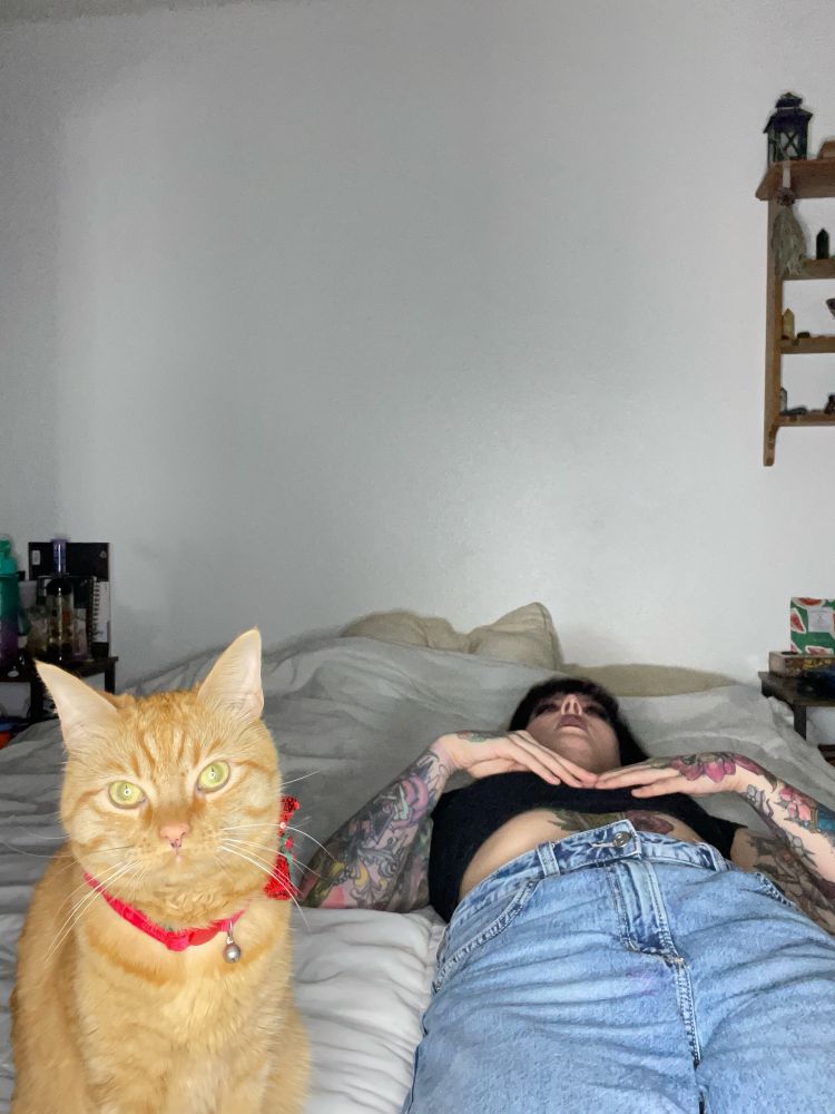 My orange cat being weird next to me while I’m laying in deep thought 