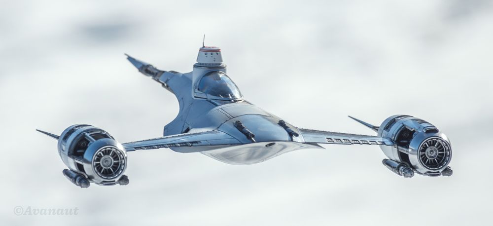 A white Naboo/Mandalorian N-1 starfighter photographed outdoors on a sunny say against white snowy background. Front quarter view, higher than eye level. 