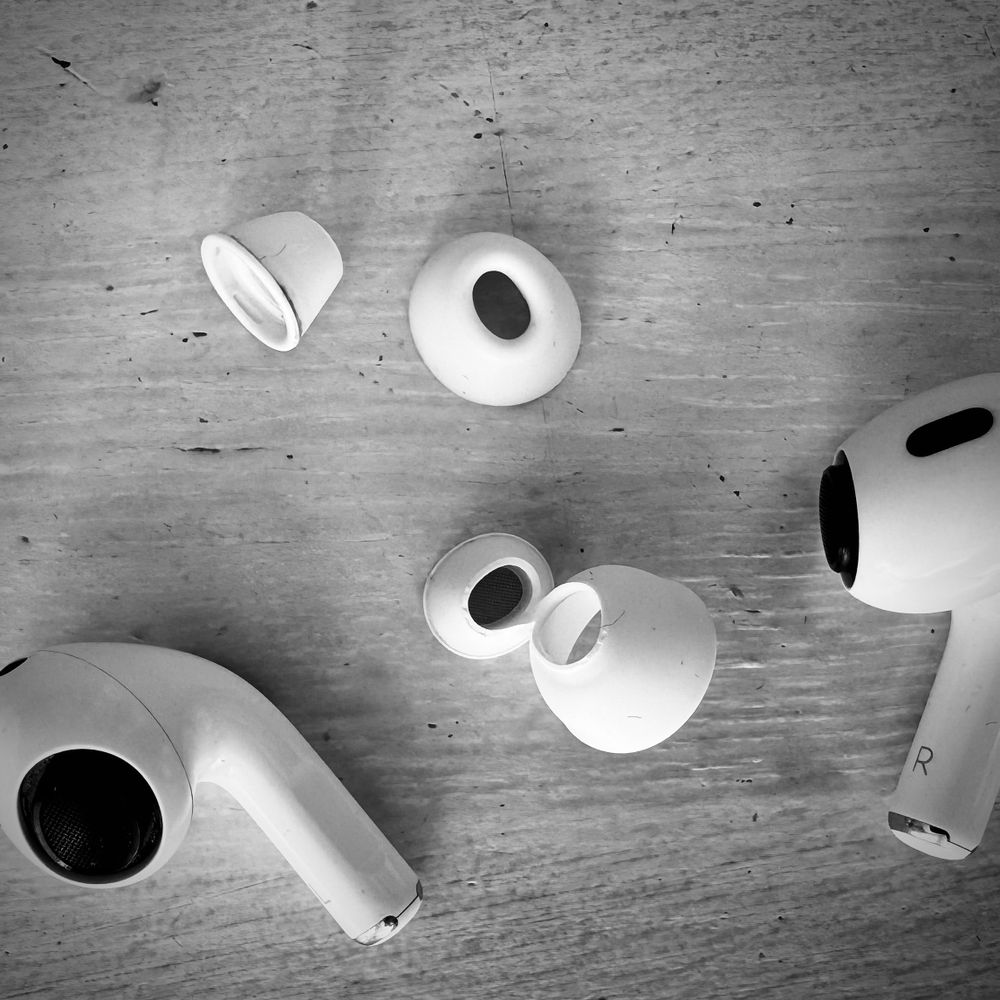 AirPods Pro with their broken tips on the kitchen table.