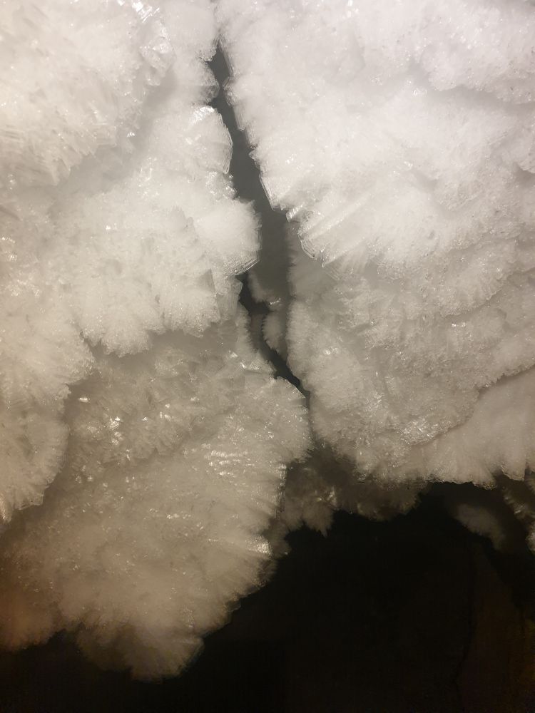 Beds of large hexagonal ice crystals inside of a cave.