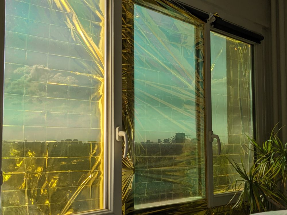 Photo d'une couverture de survie en situation : coincée par les fenêtres qui sont fermées dessus.
1er battant, elle est dehors.
2e battant, elle est dedans.
3e battant, elle est dehors.
J'ai fait en fonction du sens d'ouverture des fenêtres.
Dans l'idéal il faudrait la découper et la coller aux vitres côté extérieur avec du scotch double face pour résister à la pluie.
La couverture se trouve en pharmacie, chez Decathlon, rayon accessoire auto dans les grandes surfaces (avec les pare-soleil)...
J'ai payé la mienne 5€ en pharmacie, marque Gilbert 210 X 160 cm.