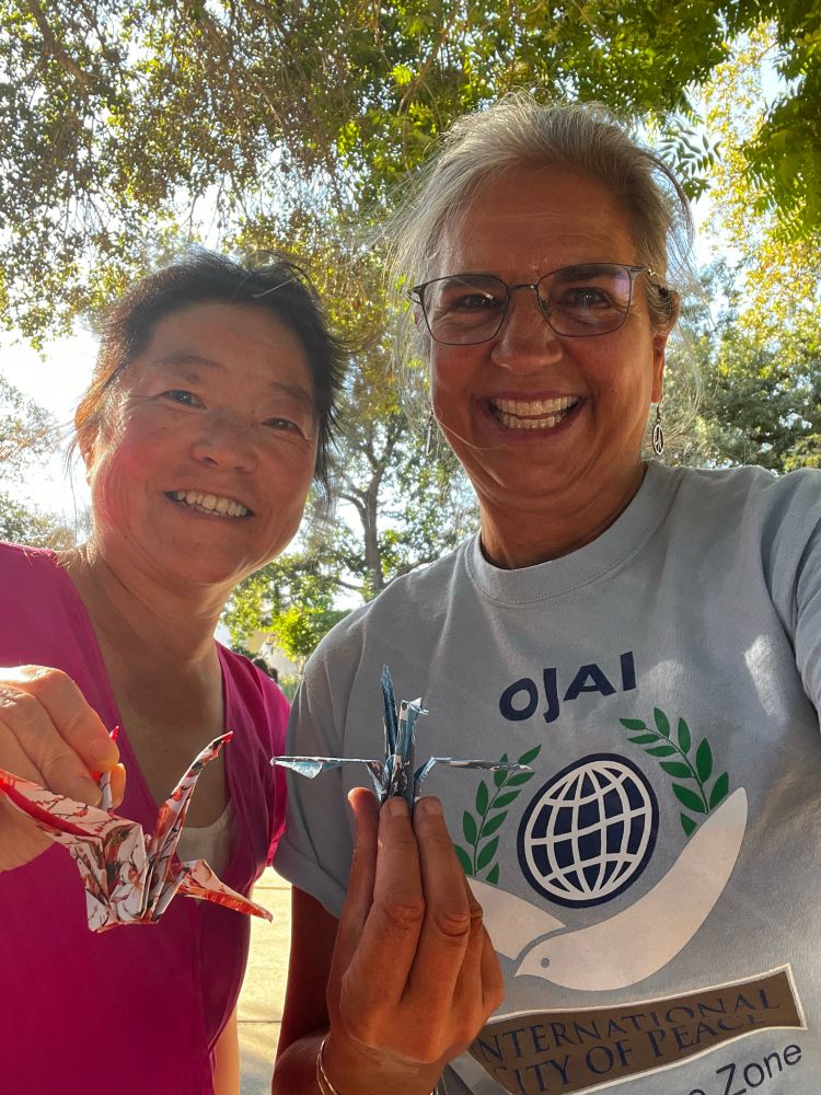 Keiko and Kristin holding up their origami cranes.