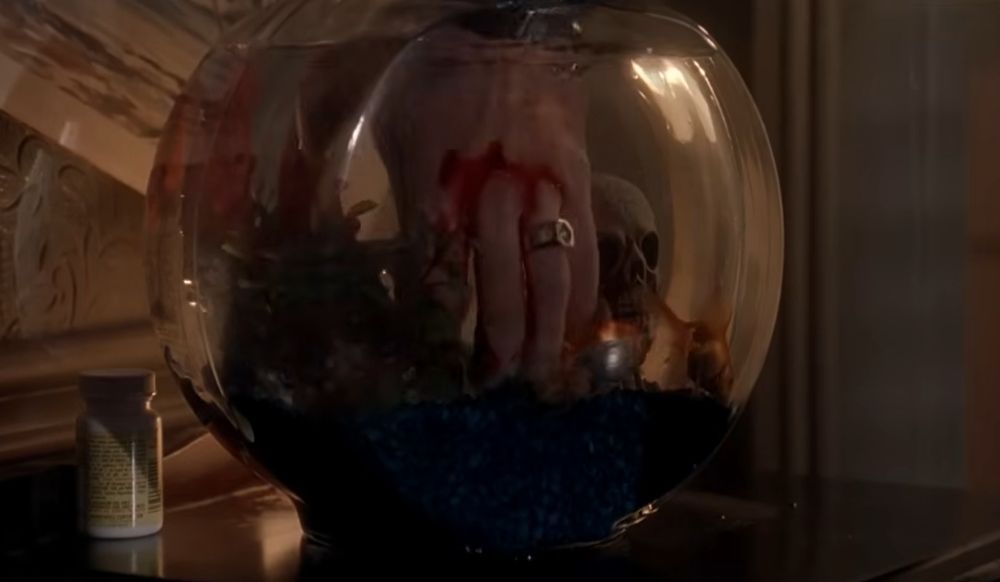 Dipping hand in fishbowl.