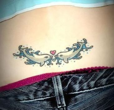 Dolphin tramp stamp with a heart above jeans beltloop