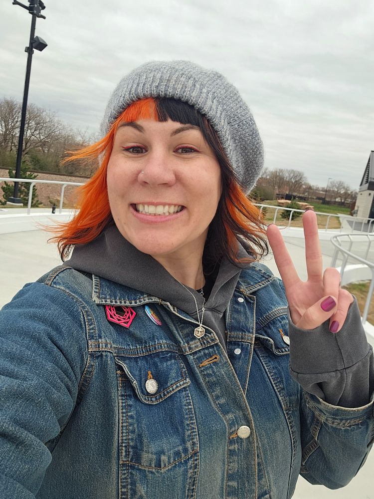 Me giving a peace sign skating at the rink