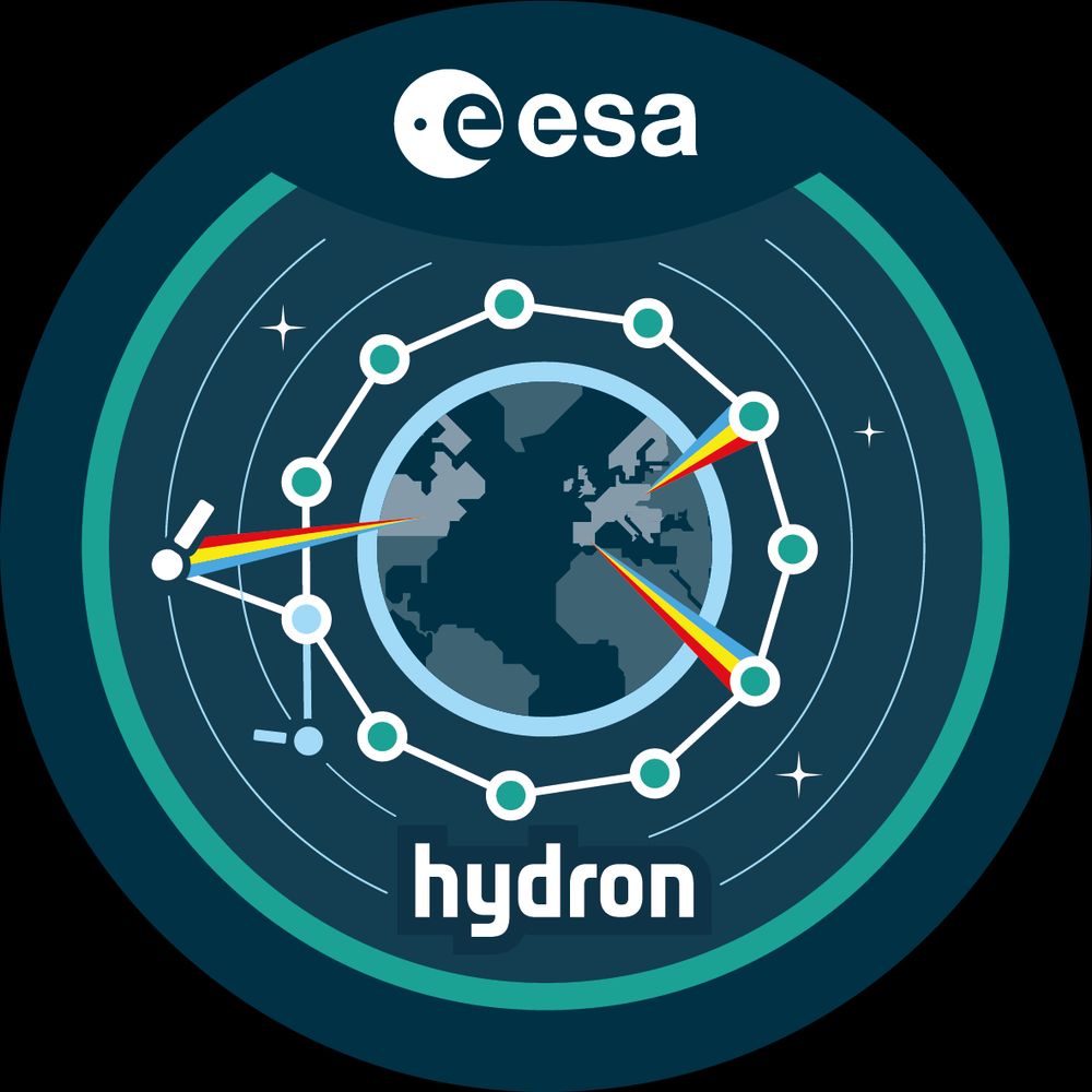A circular ESA mission emblem showing Earth surrounded by an orbiting ring of connected nodes. Several nodes emit rainbow-coloured laser beams toward Earth, symbolizing optical communications. The background features orbital lines and stars, with the word ‘hydron’ at the bottom of the emblem.
