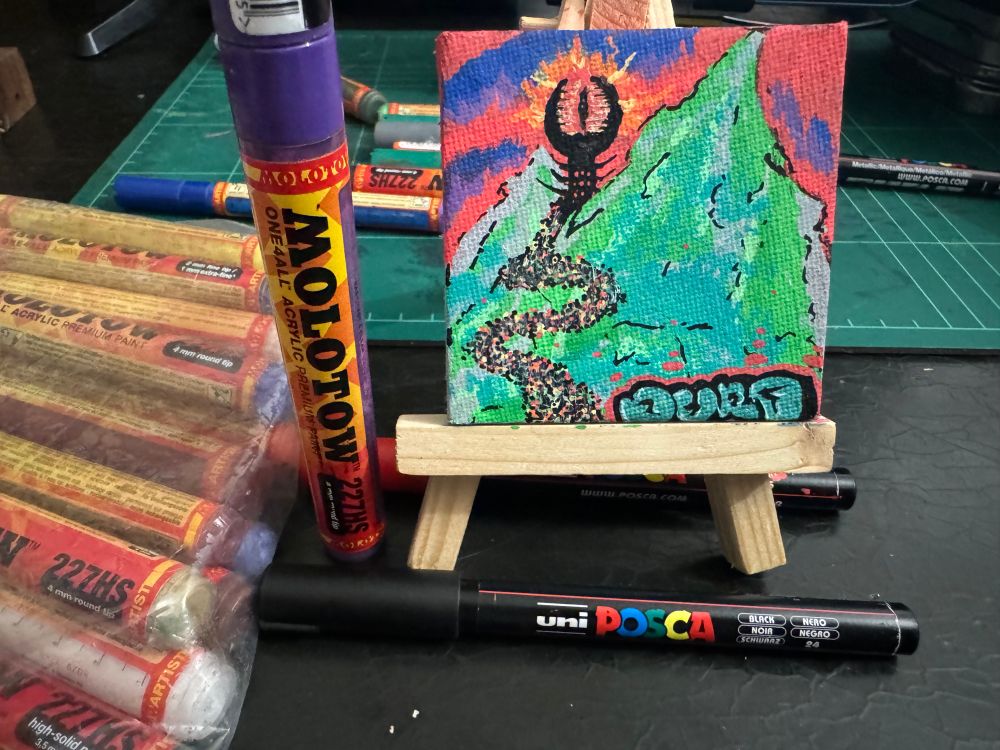 3x3 inch canvas done with markers a lord of rings theme of mountains with eye of sauron in rear perspective with dots indicating orc army marching through valleys to war 