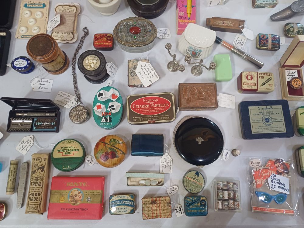 Photo of a tabletop covered with small collectables such as compact mirrors and tins.