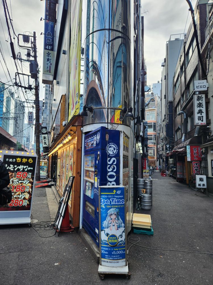 A tall wedge building with two drink vending machines cleverly designed to fit the wedge edge 