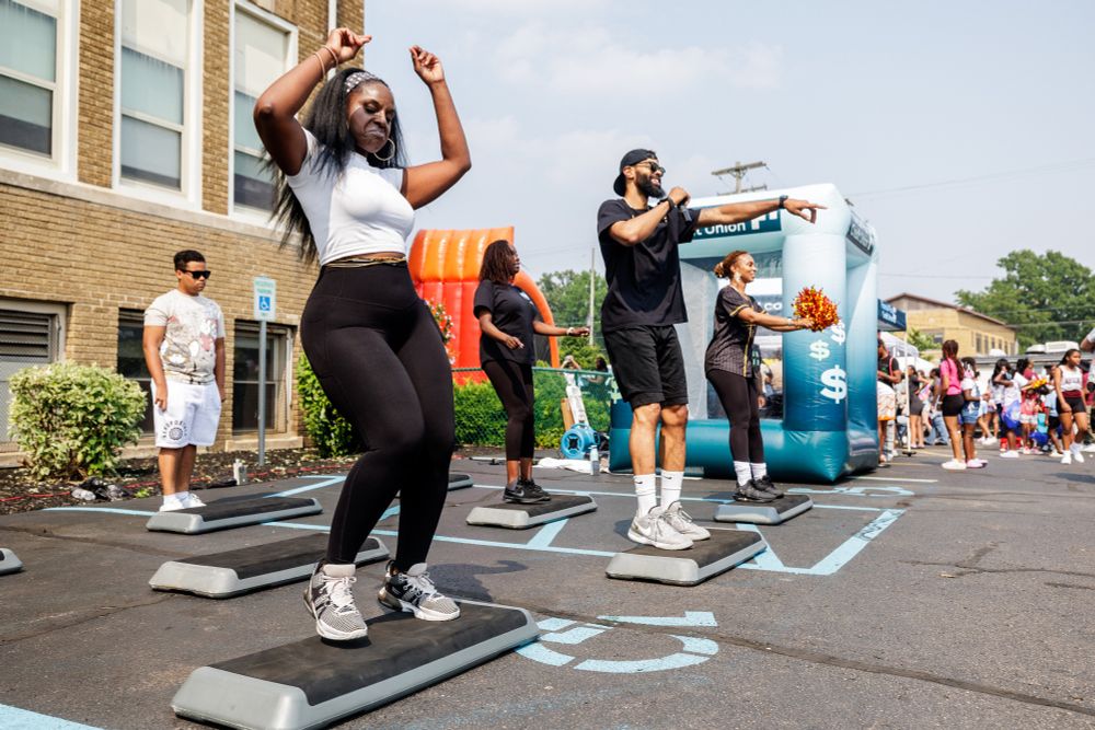 A group of people lead an outdoor fitness activity.