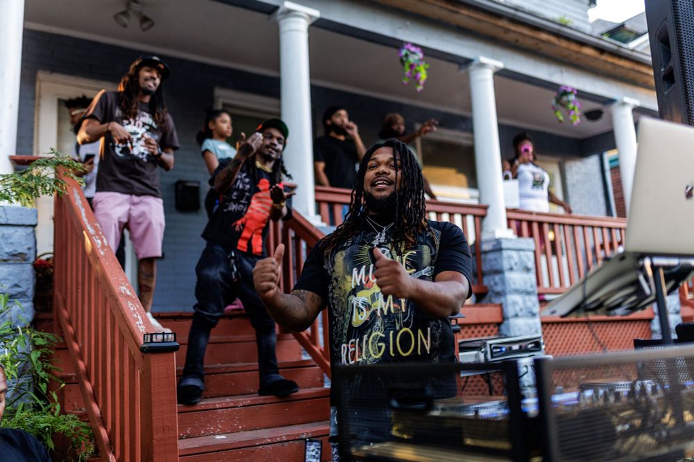 A group of people have fun while gathered on and in front of a porch.