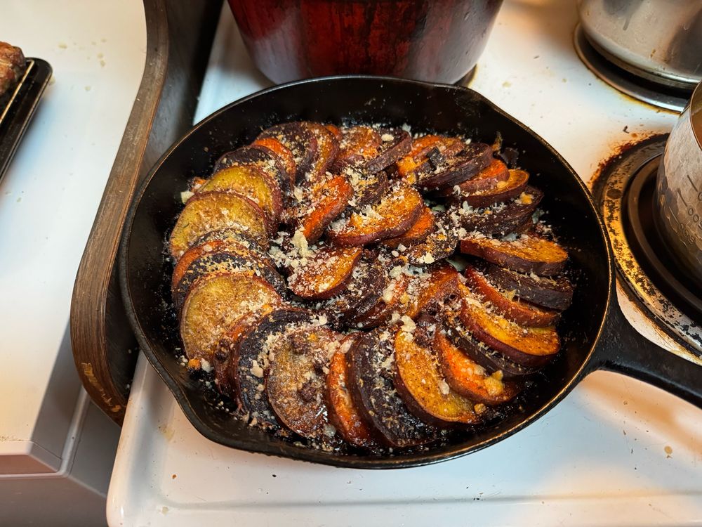 Baked candied sweet potato made withHawaiian  sweet potatos, purple sweet potatos, white sweet potatos and yams in a browned butter, brown sugar and maple syrup Cajun dressing.