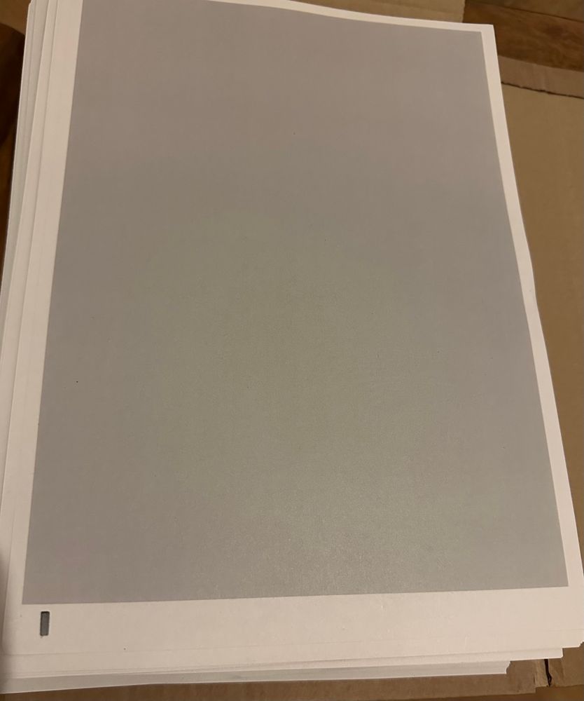 Eine komplett geschwärzte DIN A4-Seite auf einem dicken Stapel Papier.