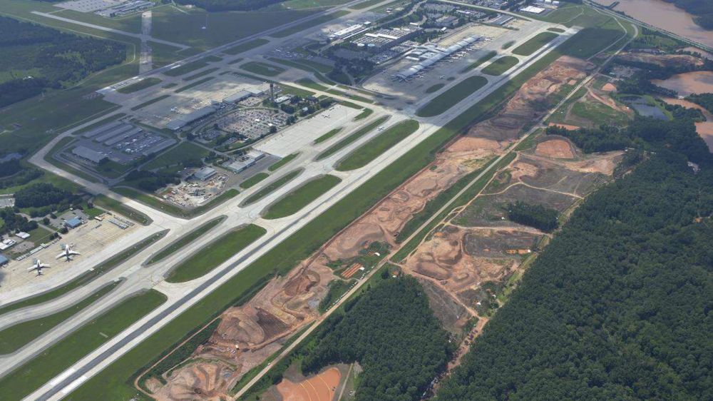 Contractors have begun moving dirt and crushed rock to smooth out the undulating landscape near Raleigh-Durham International Airport’s main runway.