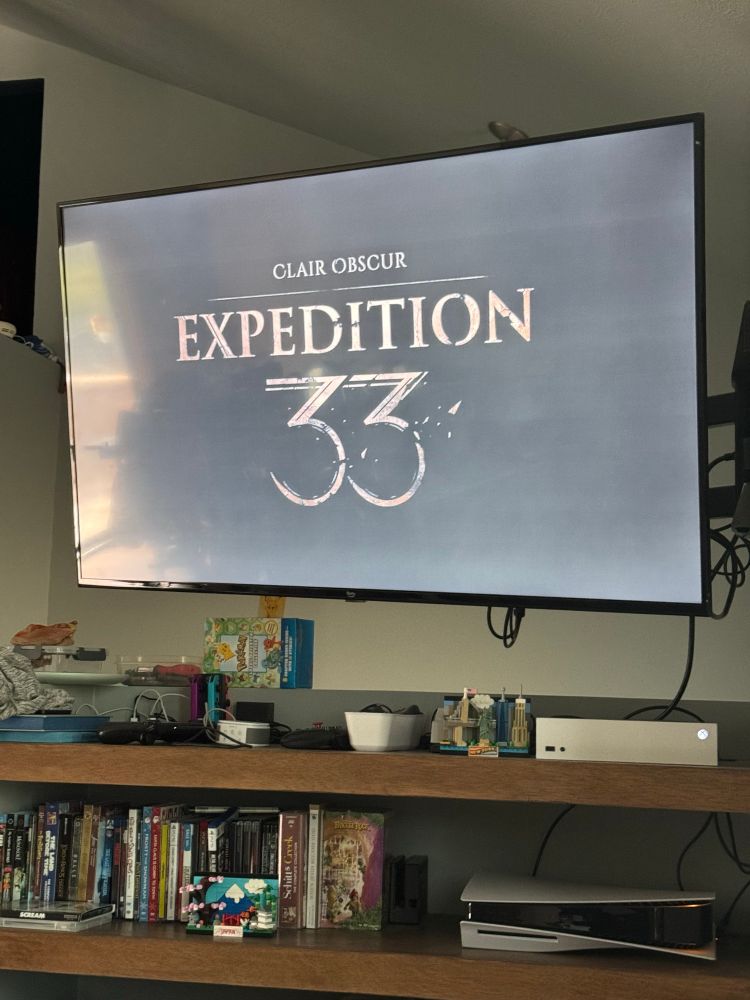 Tv screen showing the final title screen for Clair Obscur: Expedition 33. 