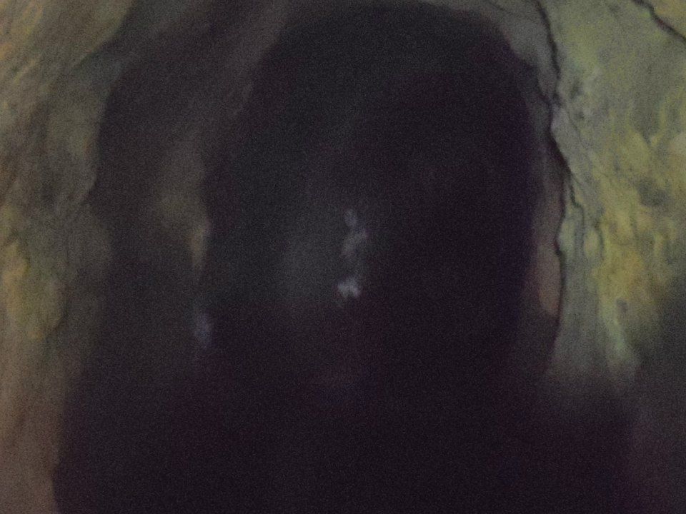 A dark tunnel with a paler "figure" in the foreground.