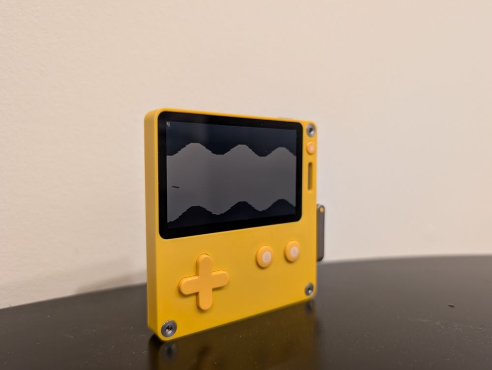 A Playdate video game console running a version of my game "Glide".