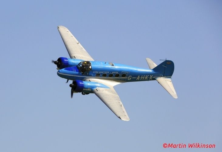 Avro Anson in a civil colour scheme flies through a blue sky at Old Warden during a Shuttleworth event.
