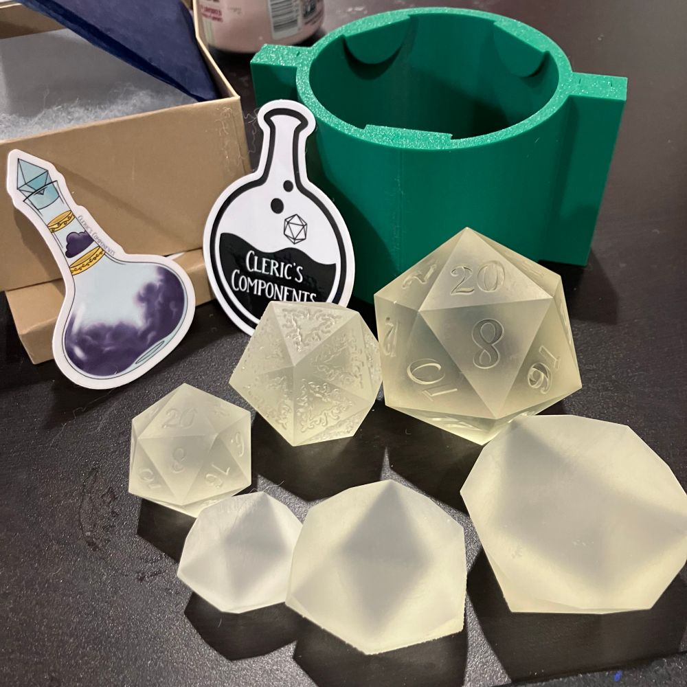 3d printed resin dice masters of various sizes and potion sticker stating Cleric’s Components