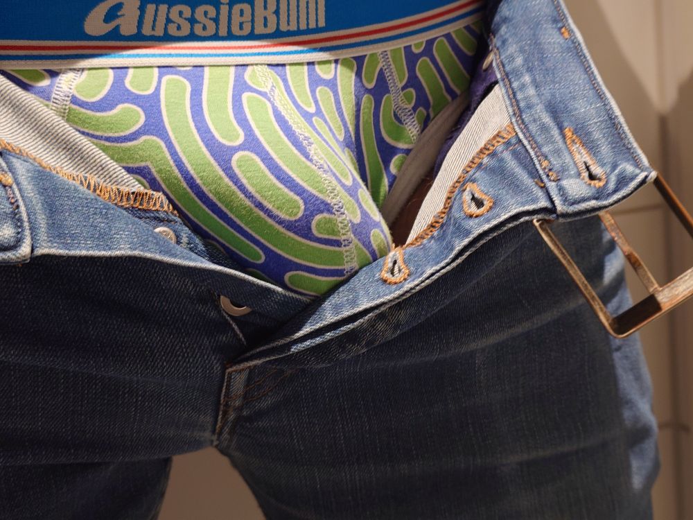 My underwear and bulge visible through unbuttoned jeans, close-up 