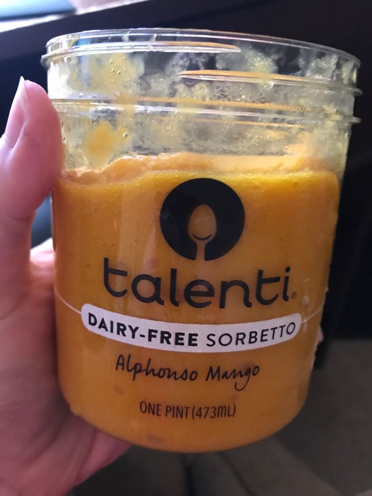 A picture of me holding a pint of Talenti dairy-free mango sorbetto.