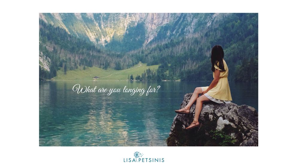 A woman sitting on a rock overlooking a lake, feeling aligned with her life.