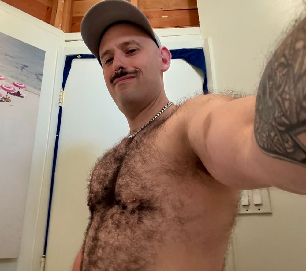 Hairy muscle otter daddy shows off his furry chest with pronounced pecs pierced nipple and a tattoo visible