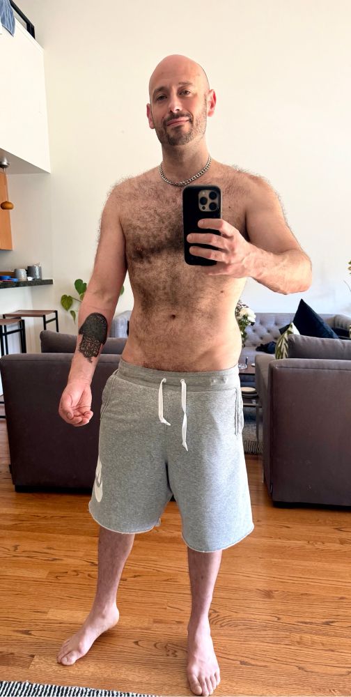 Hairy muscle otter daddy poses in a mirror selfie and shows off his first tattoo
