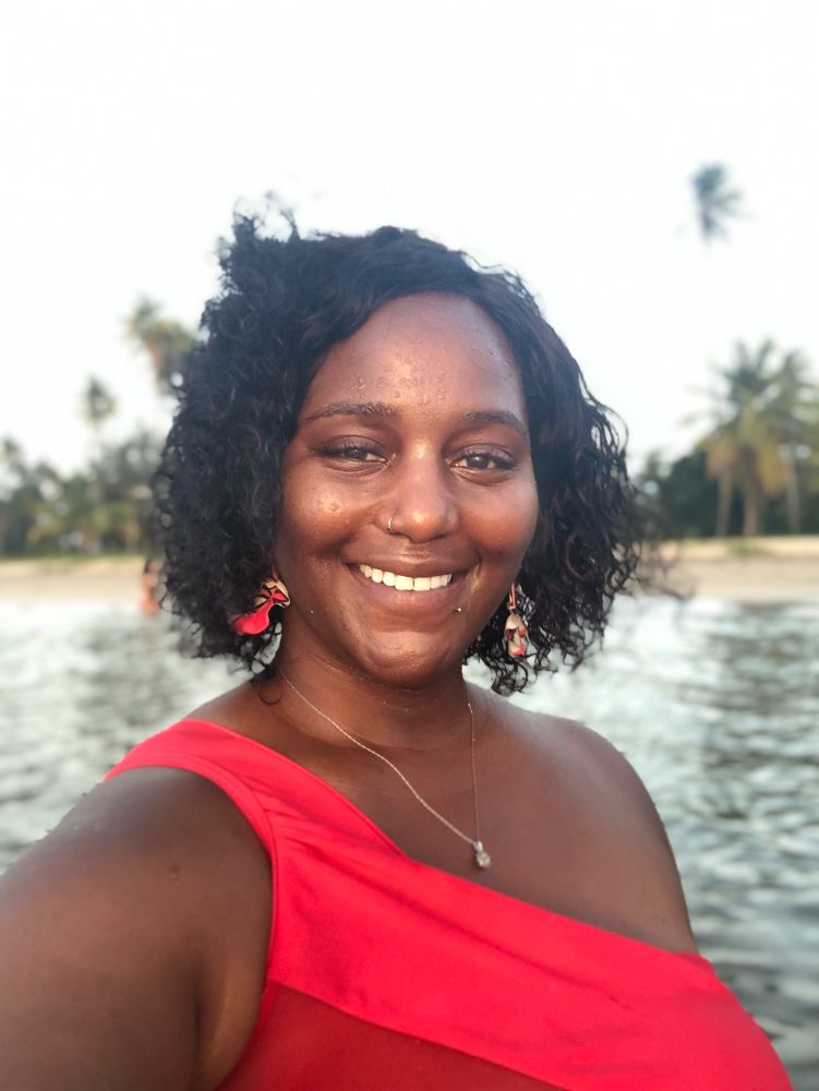 Selfie of me on the beach in a red, one-shoulder bathing suit 