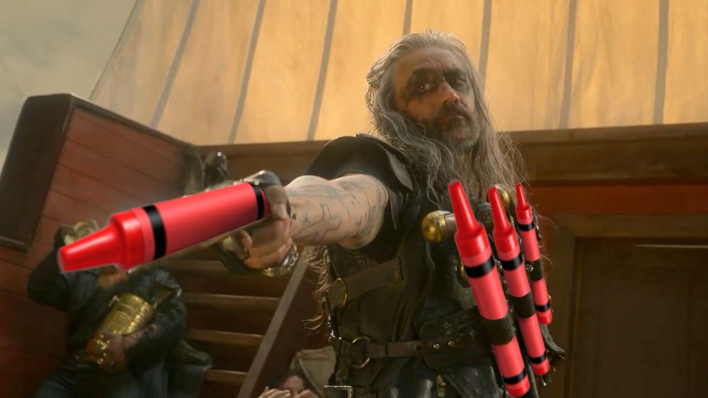 A screenshot of Ed Teach, shooting a crayon while wearing three crayons on a harness on his chest. He’s gonna’ color. 

The crayons are emoji that have been superimposed over the weapons he wears and holds in this scene from the show. 