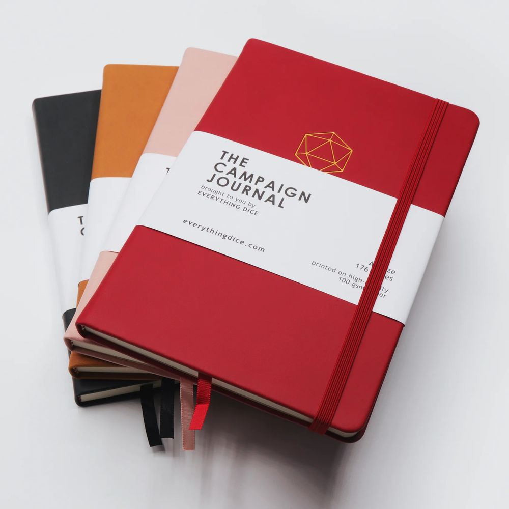 Small stack of hardcover campaign notebooks on a white background. The colors are red, pink, tan, and black.