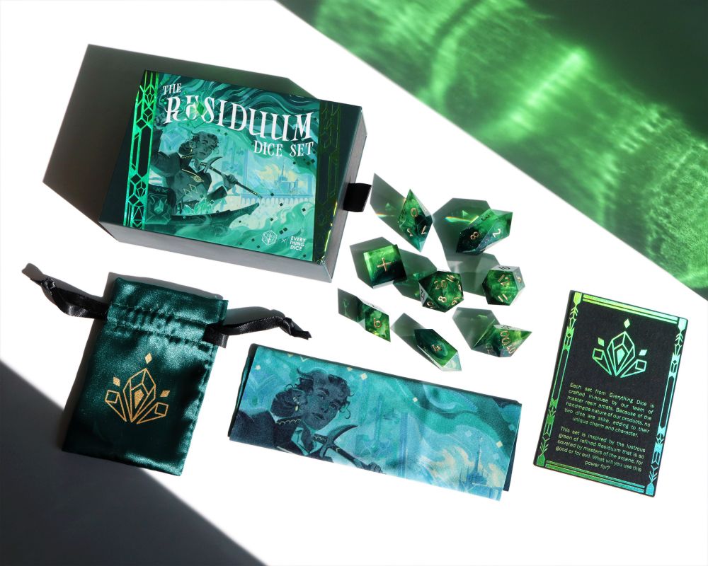 Asssorted items that come with the set laid out with the dice set, including the illustrated vault, drawstring bag, polishing cloth, and item description card.