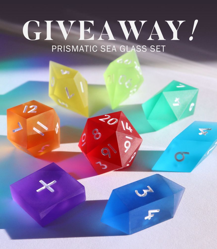 A set of 8 gaming dice arranged in a circle with the D20 in the center. Each die is a different color of the rainbow and made to look like frosted seaglass in colors of red, yellows, greens and blues. The die are all more crystal shard shaped than the average gaming set. The next above the dice reads “Giveaway! Prismatic Sea Glass Set”.