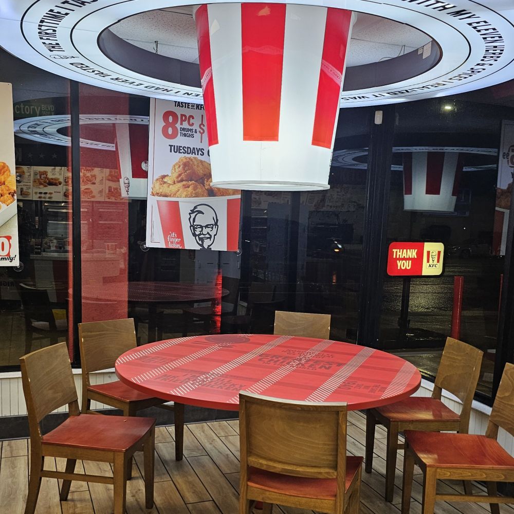 Umm. A giant bucket shaped ceiling lamp hung above a round table in an empty KFC. (It's raining outside)