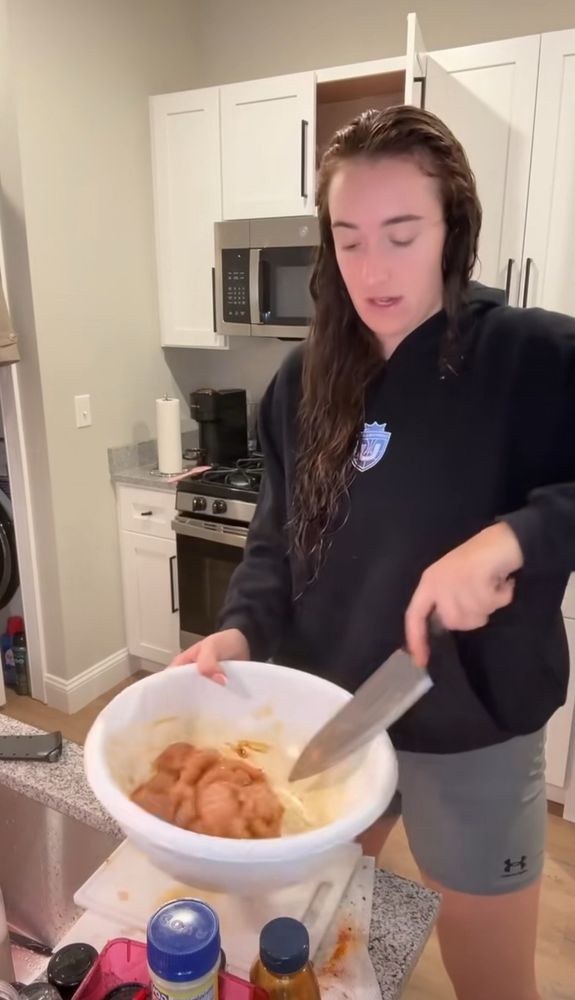 Marina Mabrey appears to be stirring a bowl of chicken with a knife?