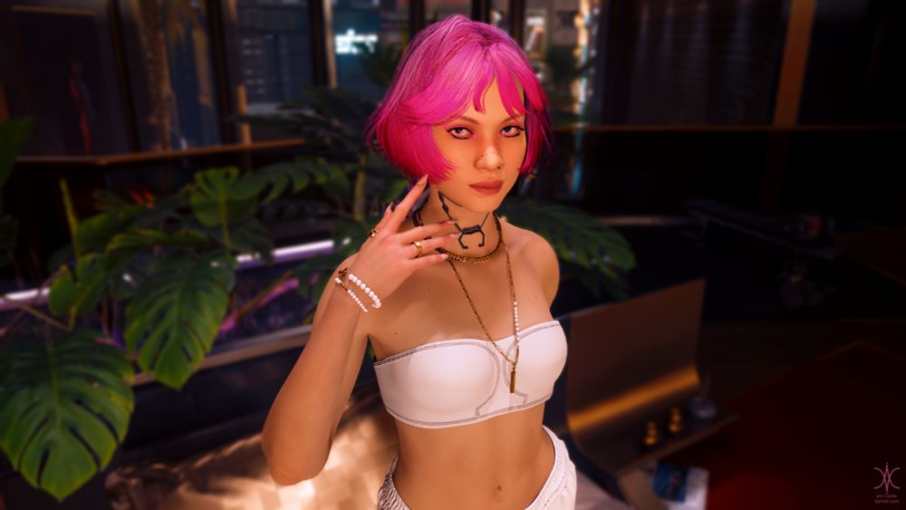A screenshot from the video game Cyberpunk 2077. A fair skinned young woman with pink hair stands indoors. Behind her, monstera leaves emerge from a planter. In the distance, city highrises can be seen through a full-wall window. The woman wears white sport shorts and a white strapless bra, along with paired gold necklaces and a pair white pearl bracelets on her raised right arm. She looks at the camera with a cool expression.