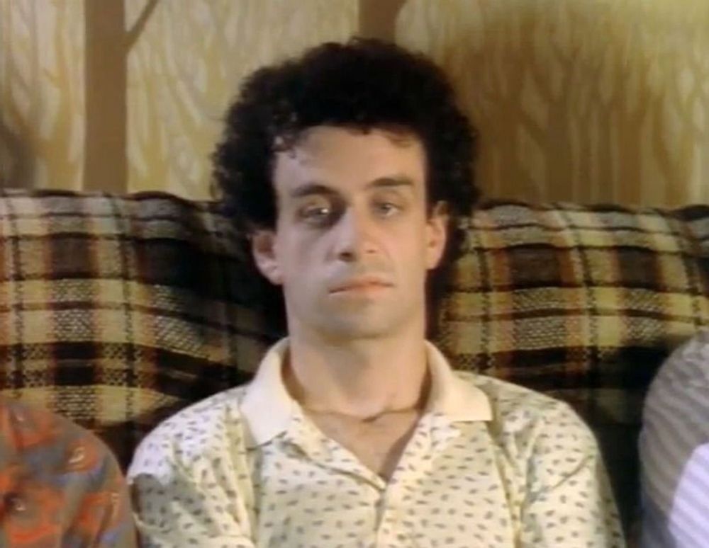 Kevin McDonals sitting on a couch with a vacant and dejected look 