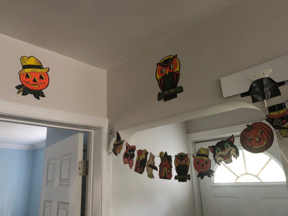 a couple of vintage halloween die cut reproductions along with a string of die cuts across the doorway (and my goofy ota antennae uhhhh duct taped to the wall - please ignore that lol)