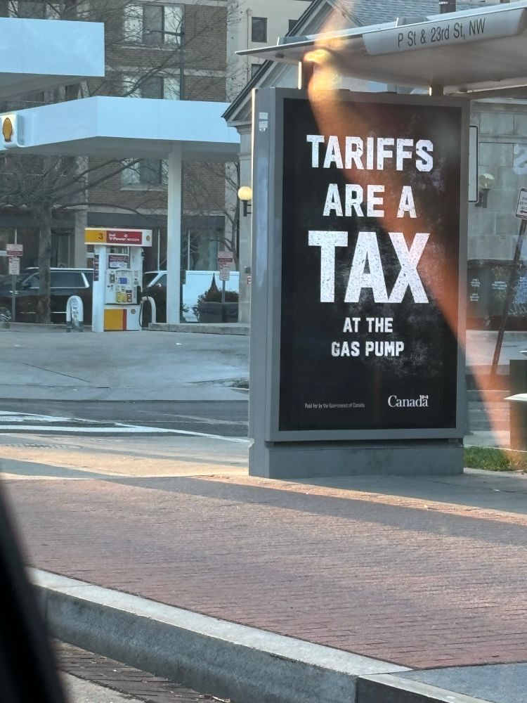 Billboard that says Tariffs are a tax at the gas pump. Sponsored by Canada