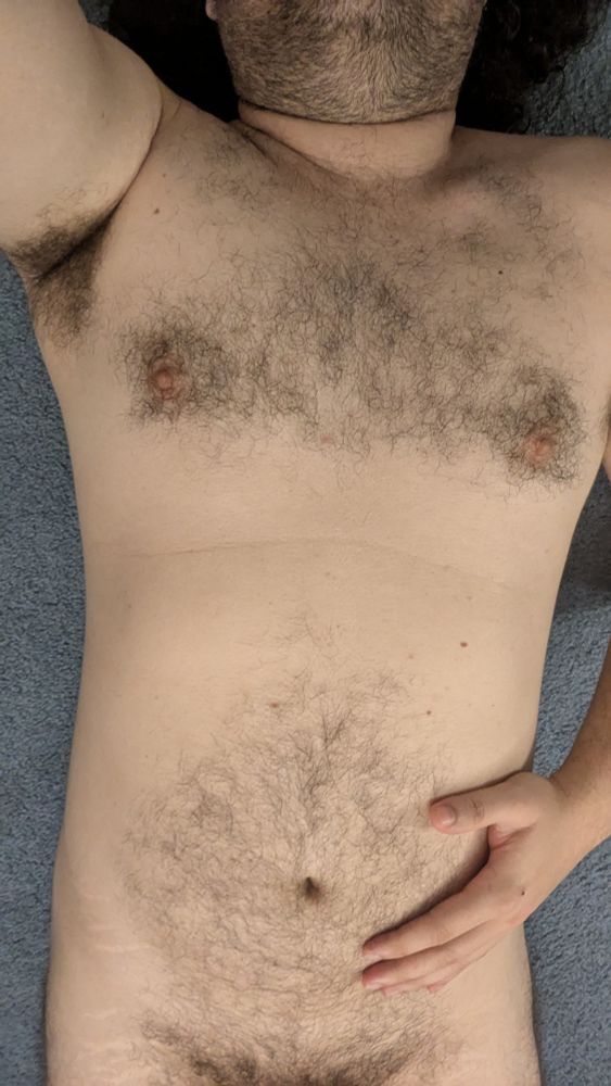 Me lying on the floor naked, cropped from low hip to chin, showing off tummy for tummy Tuesday, one hand on tummy